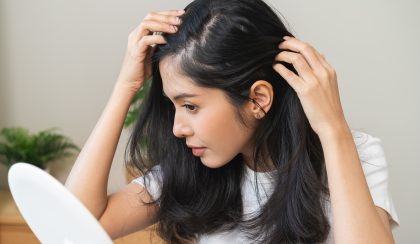 Damaged hair symptom, problem hair fall asian young woman, girl worry about balding, looking at scalp in mirror, hand in break into front hair loss, thin problem. Health care treatment for beauty.